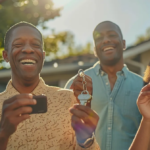 a diverse group of smiling homeowners proudly holding their house keys in front of their new homes.